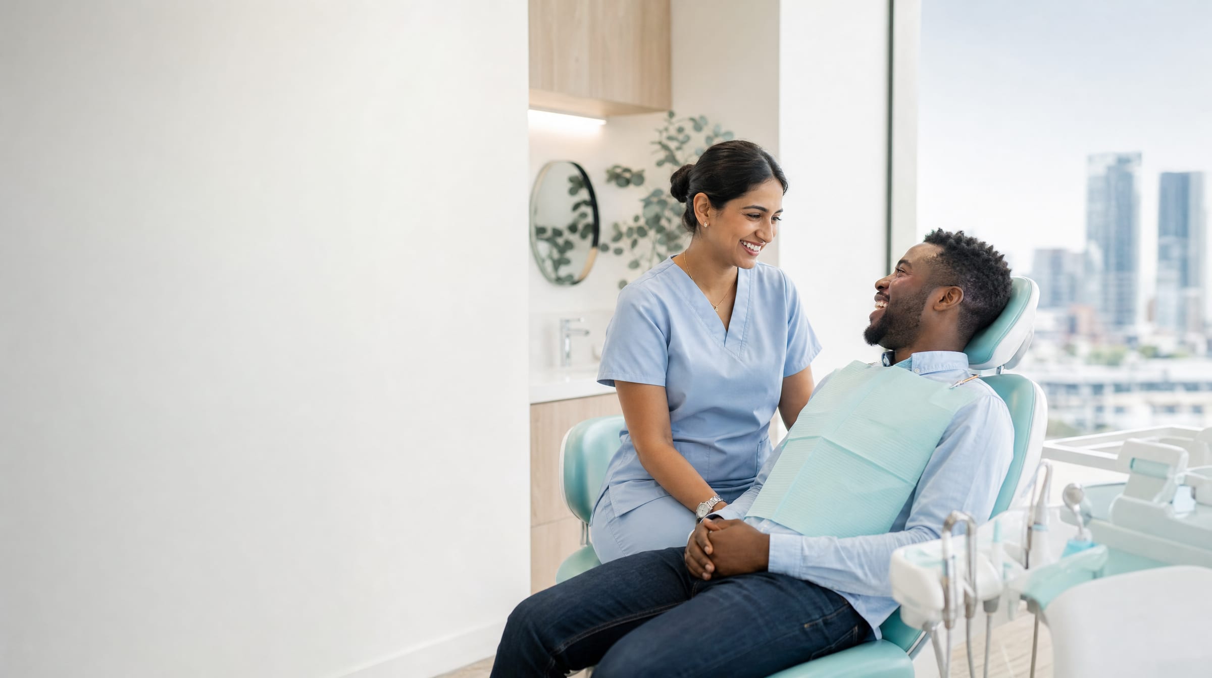 A dentist and patient smiling together in a bright, modern treatment room.
